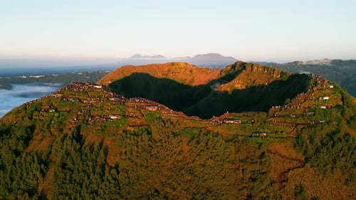 Randonneurs sur la crête de la montagne au lever du soleil avec un terrain volcanique accidenté et une vue aérienne panoramique par drone