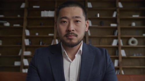 Man in Suit Stares Seriously Into Camera