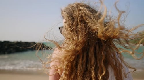 Healthy Long Hair Blowing in Wind Pretty Curly Model with Airy Strong Hair Posing at Coast Sea Surf