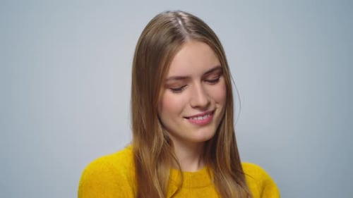 Smiling Woman Twirling Hair in Studio Portrait