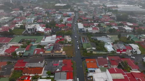 Forwards Fly Above Buildings and Streets in Residential Urban Borough on Rainy Day