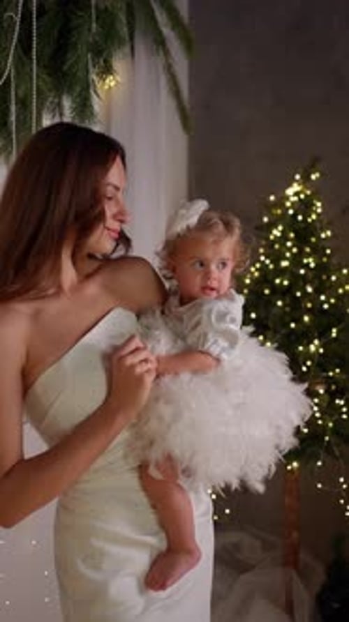 Mother Holding Her Little Daughter Near a Decorated Christmas Tree Concept of Family New Year
