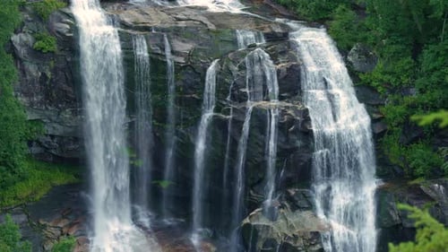 Whitewater Falls with Falling Down Clear Water From Rocky Boulders Between Green Lush Woods in