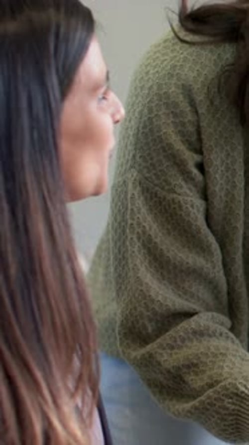 Vidéo verticale : une femme qui parle à gauche initiant la réponse, la bouche bougeant dans la pièce, une montre en pull olive