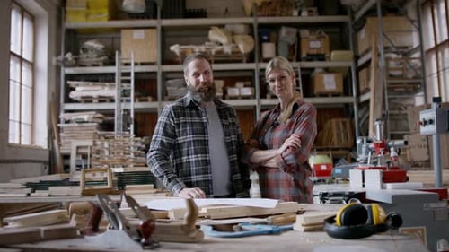Carpenters in workshop making design of products for their small business looking at camera