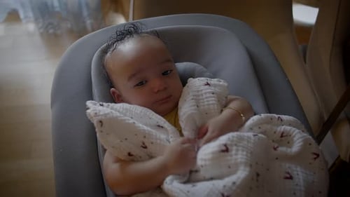 Cute Baby Resting Comfortably in a Gray Seat
