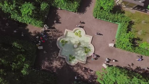 Summer Garden, an aerial drone footage of a fountain on a 3rd alley, fly in over the top, straight d