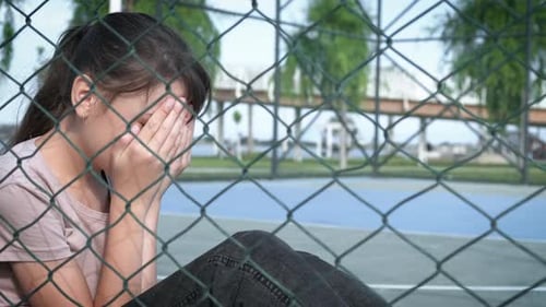 Crying teenager on the playground.