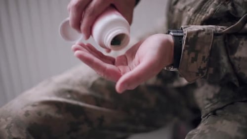 Man in Military Uniform Taking Medication Pills
