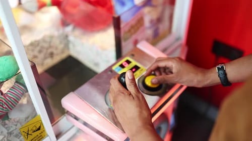 Frau spielt Klauenkranich-Spiel und versucht, einen Preis zu ergattern