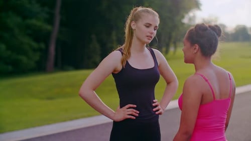 Frau spricht mit blondem Mädchen. Freundinnen unterhalten sich im Sommer im Park