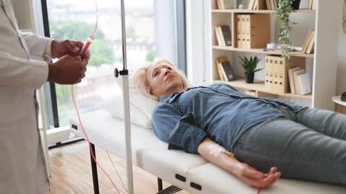 General Practitioner Checking Tubes Which Blood Flows of Female