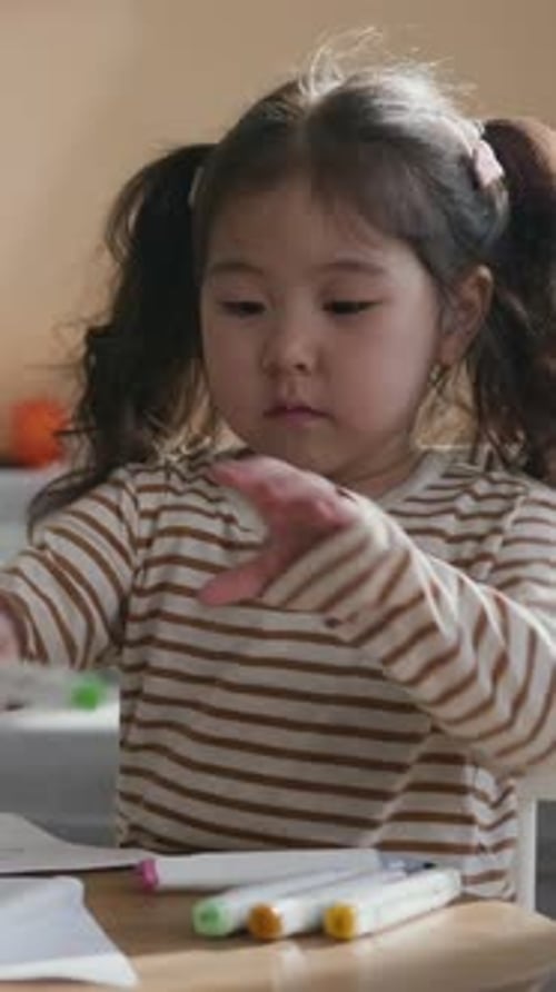 Cute Child Drawing on Paper with Colorful Markers