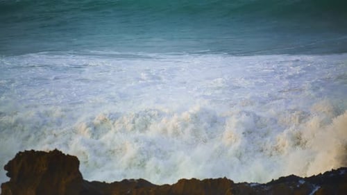 White Sea Waves Hitting Rocks Beach in . Foaming Stormy Ocean