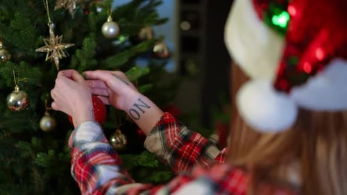 Festive Young Adult Decorating Christmas Tree at Home