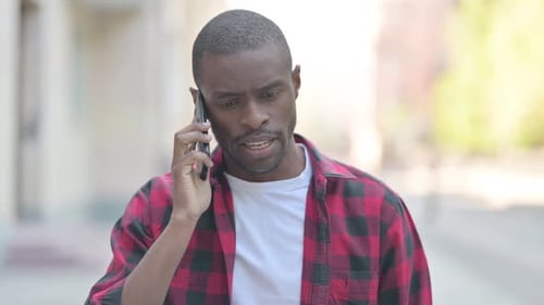Young Adult Talking on Cell Phone Outdoors