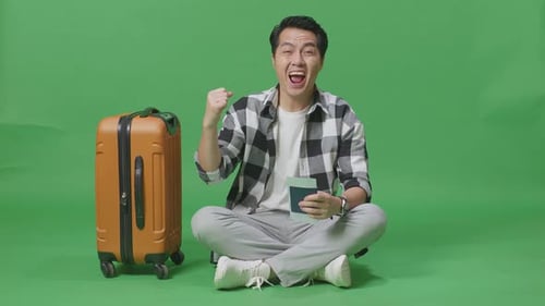 Male Traveler With Luggage And Passport Then Celebrating While Sitting In The Green Screen