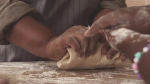 Family Kneading Dough Together in Home Kitchen