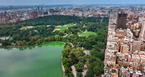Marvelous scenery of Central Park with lake. Sunny cityscape of New York from aerial perspective.