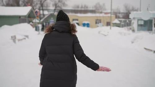 Athletic Girl Dressed in Long Winter Coat Knit Hat and Colorful Mittens Outdoors