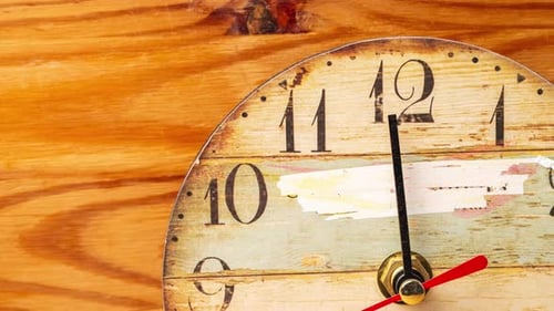 Time lapse clock on wooden background.