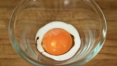 Milk is being poured on an Egg Yolk to make egg wash (close up top view)