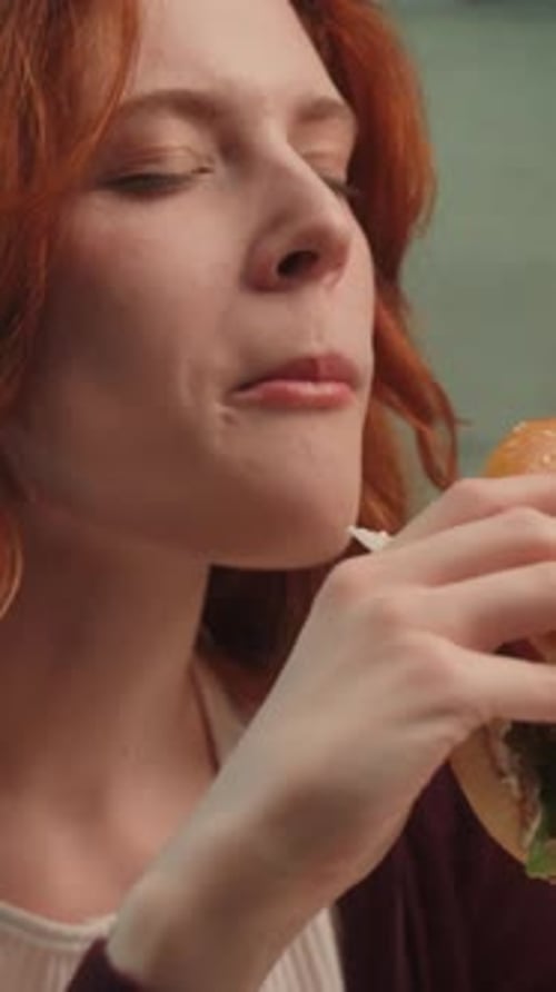 Woman Enjoying Delicious Burger in Urban Setting