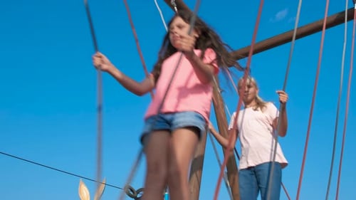 Kids Traverse a Rope Bridge on a Playground