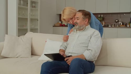 Mature Couple Using Tablet in Bright Home Setting