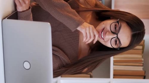Smiling Woman Using Laptop for Video Call at Home