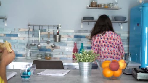 Couple talking in bright kitchen at breakfast table
