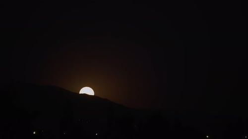 Super moon rising behind a mountain