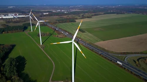 Wind farm Windmill turbines near highway clean energy. Amazing aerial view flight drone