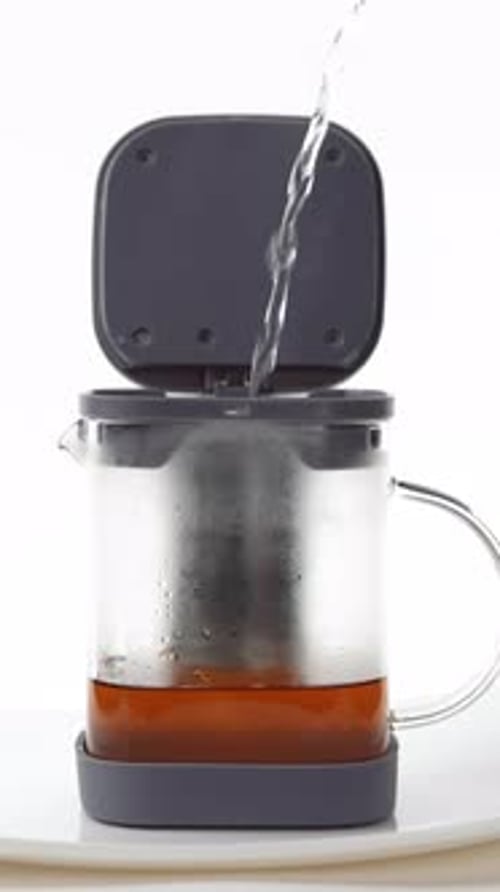 Water Pouring Into a Glass Tea Kettle