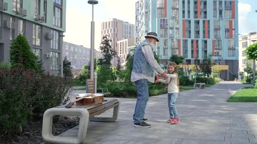 Senior Man Dancing with Young Girl Outdoors