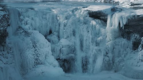 Wasser fließt durch einen fast gefrorenen Wasserfall. Winterlandschaft