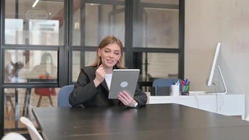 Young Businesswoman Doing Video Chat on Tablet in Office