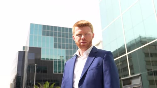 Businessman Leaning Outside a Financial Building Looking Up