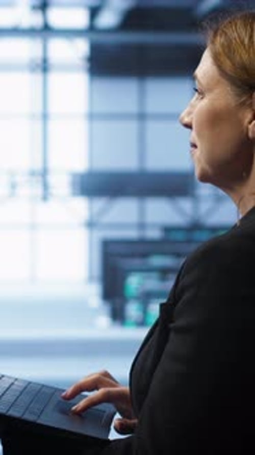 Vertical Video Smiling IT Expert Uses Notebook in Data Center Workspace