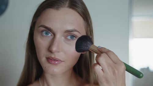 Woman Applying Makeup with Brush Close Up