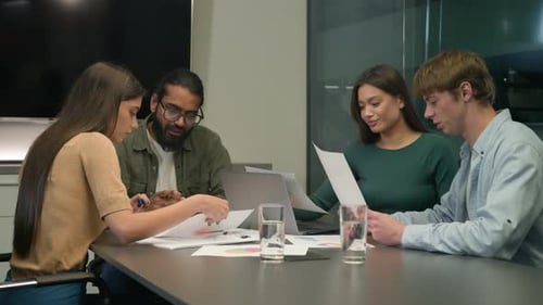 Diverse Team Collaborating on Documents in Modern Office