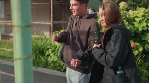 Young couple visit outdoor aviary on a sunny day