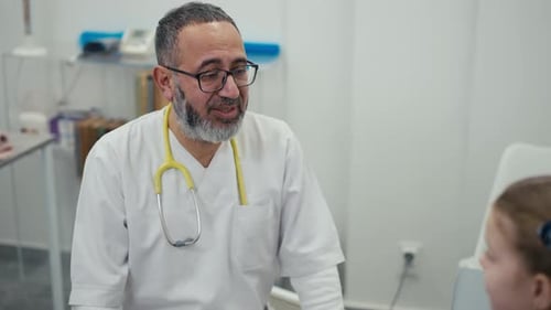 Caring Doctor Hugs Little Girl in Hospital