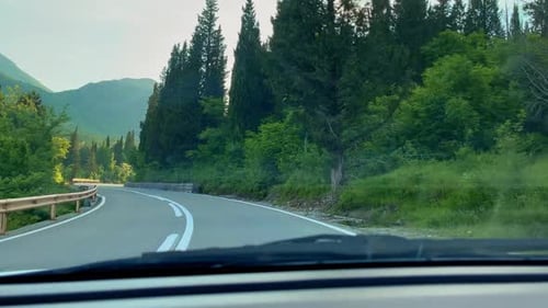 Road Trip on a Car Through Mountains During Sunset