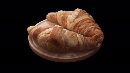 Loop-Animation rund um eine Komposition aus zwei Croissants, die auf einem Holzbrett liegen