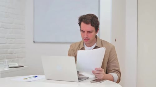 Adult Working at Laptop, Reviewing Documents