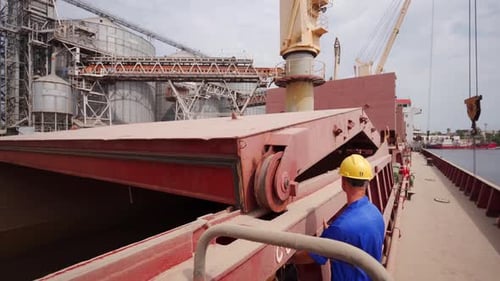 Seafarer Closing Cargo Holds on Bulker Ship at Grain Terminal in Sea Port After Loading Crops