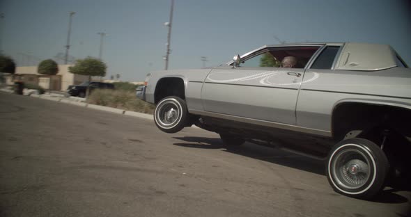 Lowrider gris conduciendo sobre 3 ruedas en Compton, California. Cámara ...