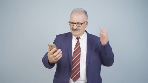 Mature Man Disapproving of Message on Smartphone