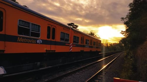 Zug fährt bei einem wunderschönen Sonnenuntergang vorbei.